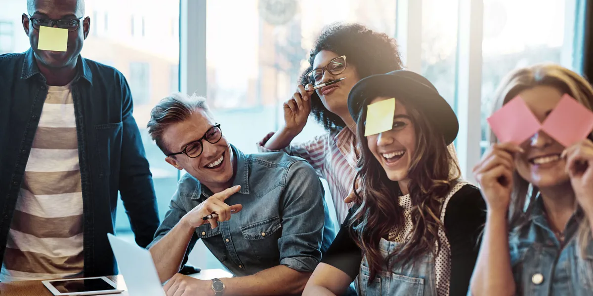 Teamitglieder haben Spaß bei der Arbeit und spielen mit Notizzetteln. © Shutterstock, Ground Picture