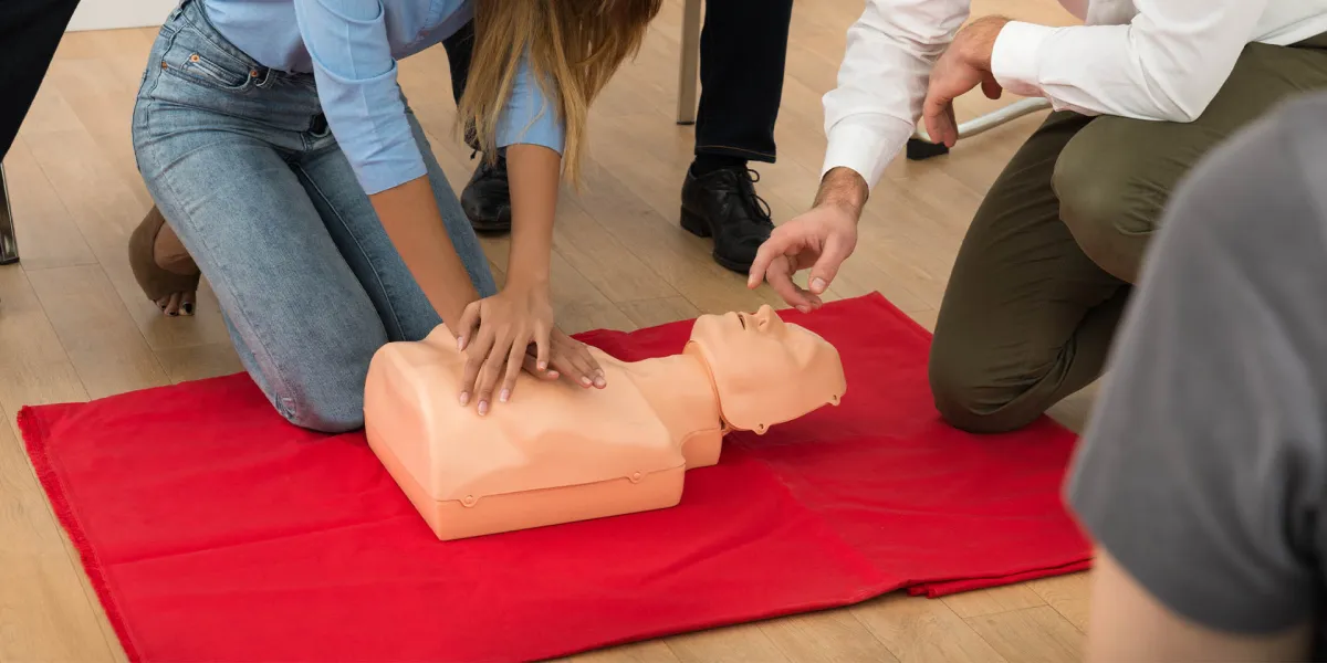 Mitarbeiter eines Unternehmens üben im Erste-Hilfe-Kurs die Herzdruckmassage an einer Puppe. © Shutterstock, Andrey_Popov