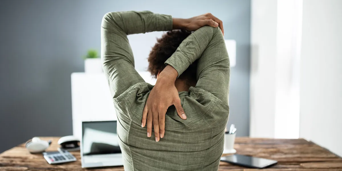 Mitarbeiterin leidet an Verspannung, da sie viel am PC arbeitet. © Shutterstock, Andrey_Popov