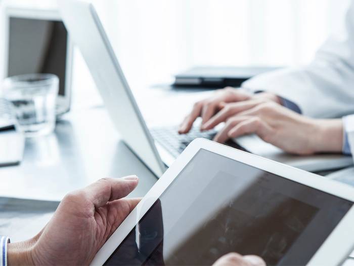 Fachkraft stimmt Sicherheitsmaßnahmen mit zwei Mitarbeitenden in einer Produktionshalle ab.