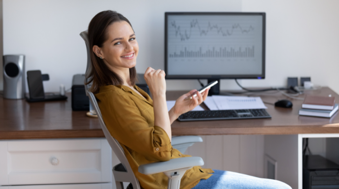 Eine Frau, die in einem bequemen Bürostuhl mit Lordosenstütze und dem Smartphone in der Hand sitzt und sich am Arbeitsplatz ausruht. © Adobe Stock, fizkes