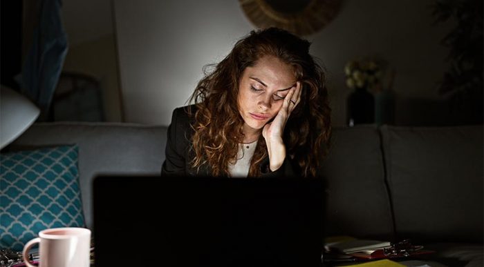 Eine Mitarbeiterin ist sehr müde und antriebslos bei ihrer Arbeit im Home-Office. © Adobe Stock, Krakenimages.com