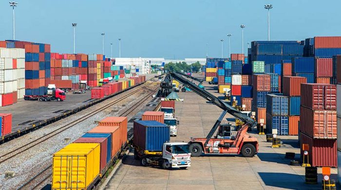 Ein Kran hebt Containerboxen auf einen Container-LKW. Zu Betriebsunterbrechungen zählen unter anderem Störungen der Lieferketten. © Adobe Stock, tuastockphoto