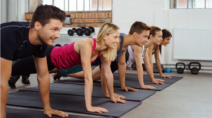 Eine Gruppe von Mitarbeitern nutzen die Möglichkeit zum Betriebssport und machen Pilates in einem Fitnessraum. © Adobe Stock, contrastwerkstatt