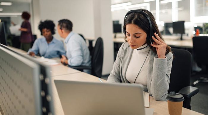 Eine Mitarbeiterin erhält im Büro einen Social Engineering-Angriff per Telefon. © Adobe Stock, Zamrznuti tonovi